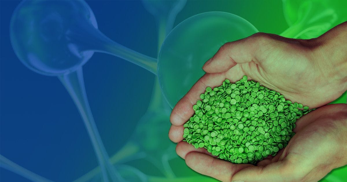 Hands holding a pile of green pellets with a background of biotechnology imagery.