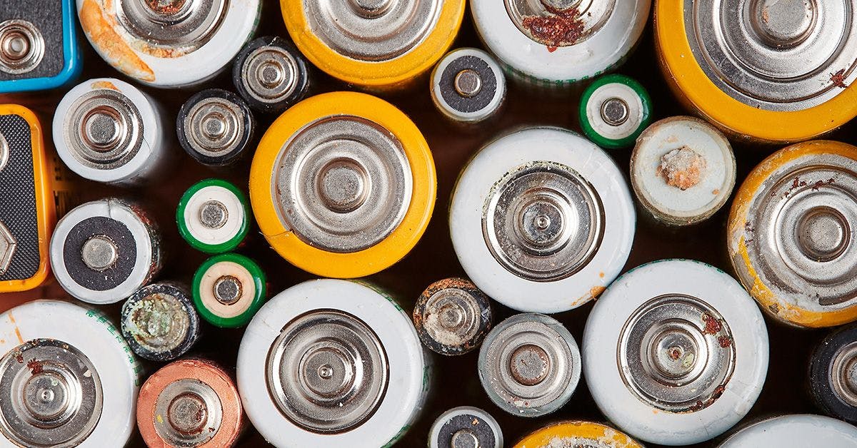 A variety of used and corroded batteries of different sizes and brands, clustered closely together.