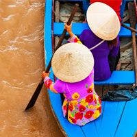 A group of women in traditional hats on a blue boat.