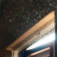 Sunlight streaming through a window, illuminating floating dust particles in the air, creating a glittering effect.