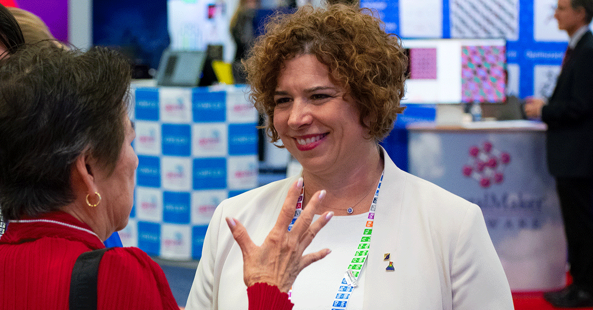 Two professionals engaged in a conversation at a business event or conference.