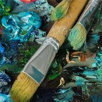 An artist's palette with brushes and paint on it.
