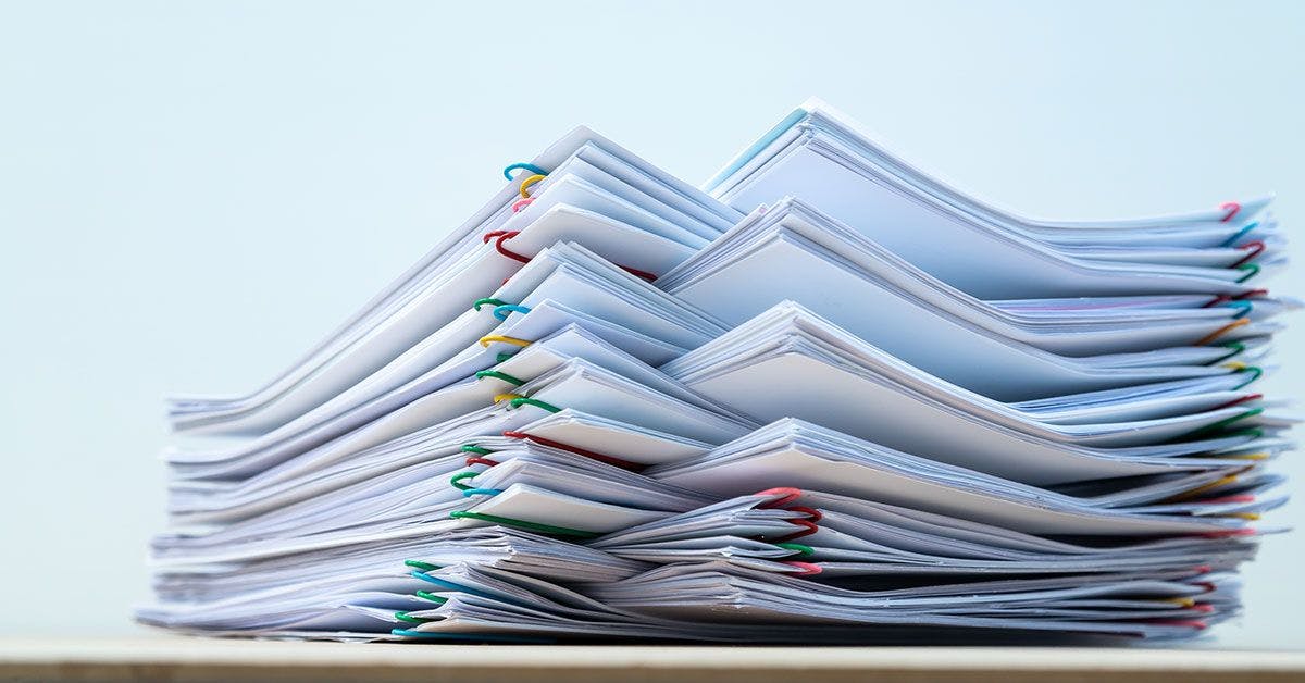 A stack of paper documents on a table.