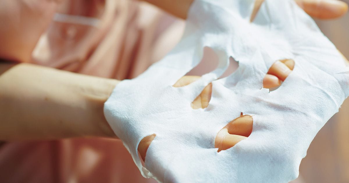 A woman's hand holding a piece of white paper.