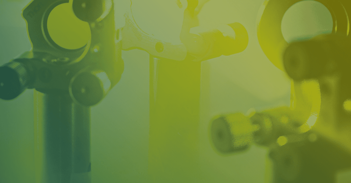 Close-up of metallic connectors and fixtures against a green gradient background, showcasing industrial design elements.