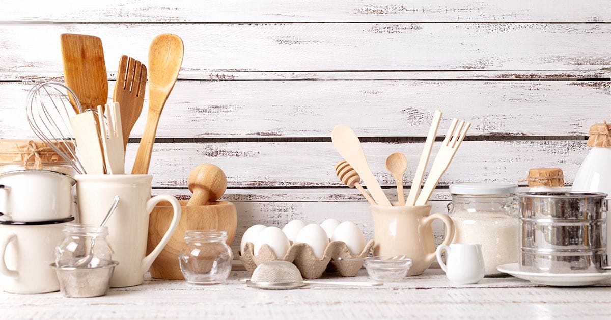 Baking kitchenware and baking products on a white wooden background.