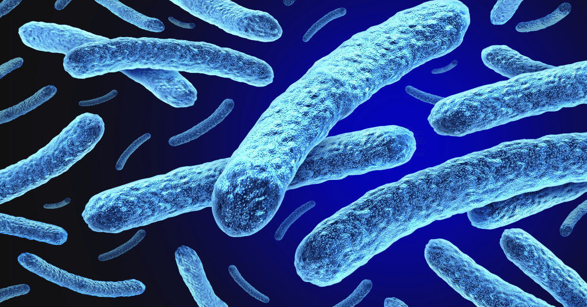 A digital rendering of blue microorganisms resembling bacteria, floating together against a darker background.