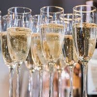 A line of champagne glasses on a table.