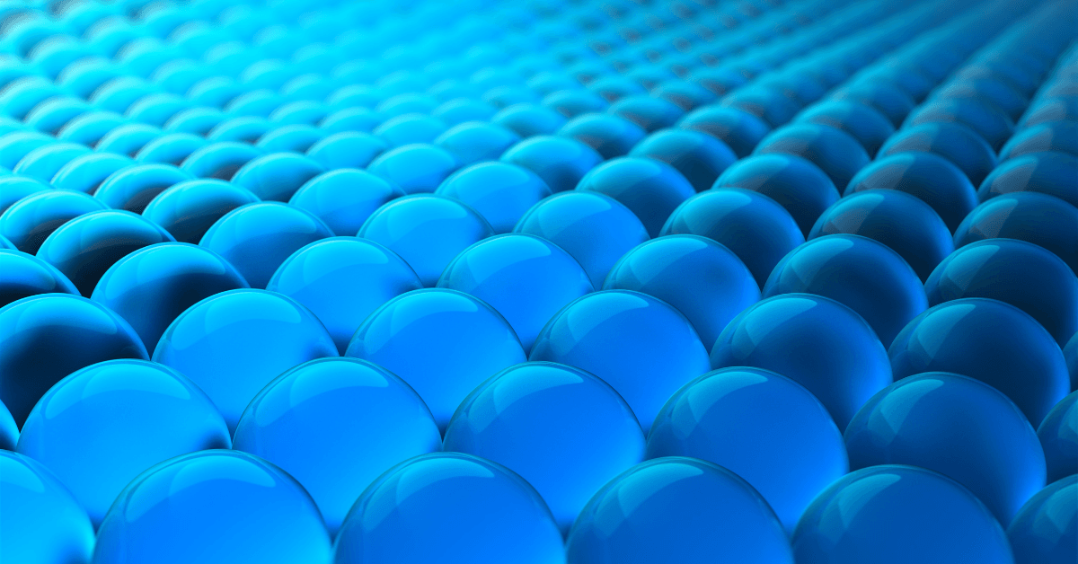 A close-up digital image of glossy blue spheres in various shades of blue, conveying structured design and order.