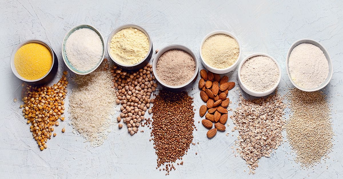 A collection of bowls side-by-side containing a variety of gluten-free flours.