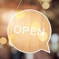 A wooden sign with the word open hanging from a chain in a restaurant.