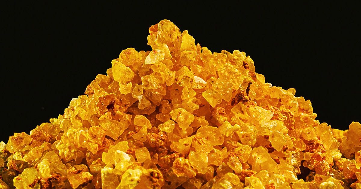 A pile of uranium crystals on a black background.