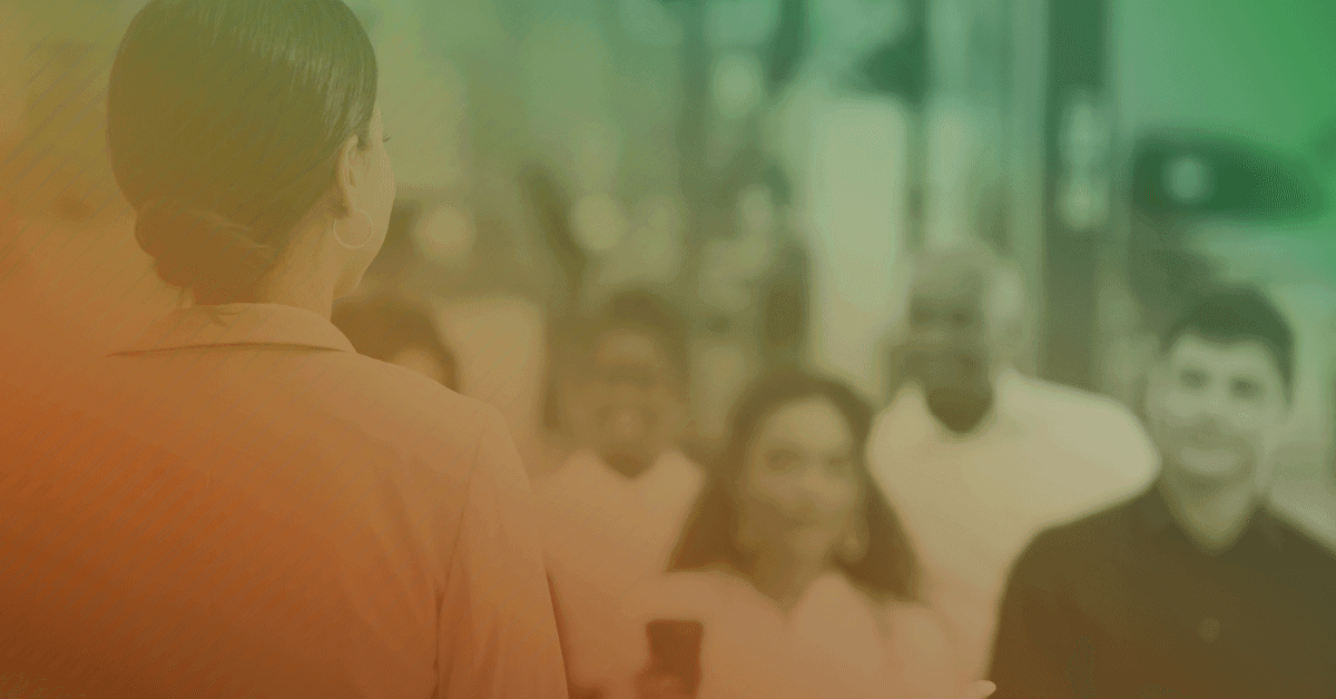 A woman is standing in front of a group of people.