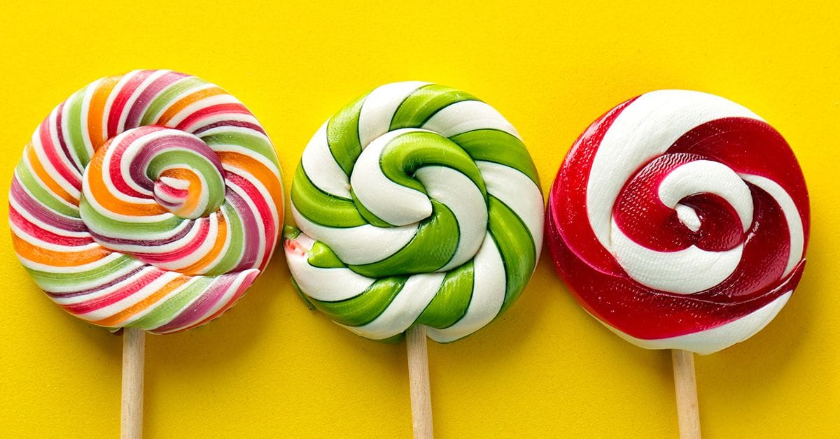 a collection of three unwrapped lollipops in various colors.