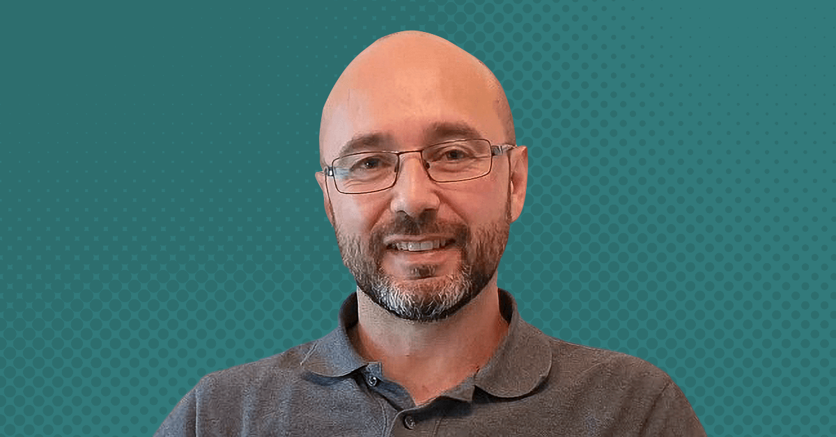 A headshot cutout of Dr. Mariolino Carta against a textured teal background.