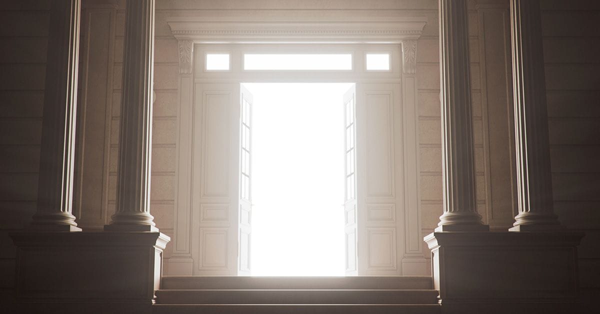 A grand classical doorway with tall columns and open doors, flooded with bright white light at the top of a staircase.