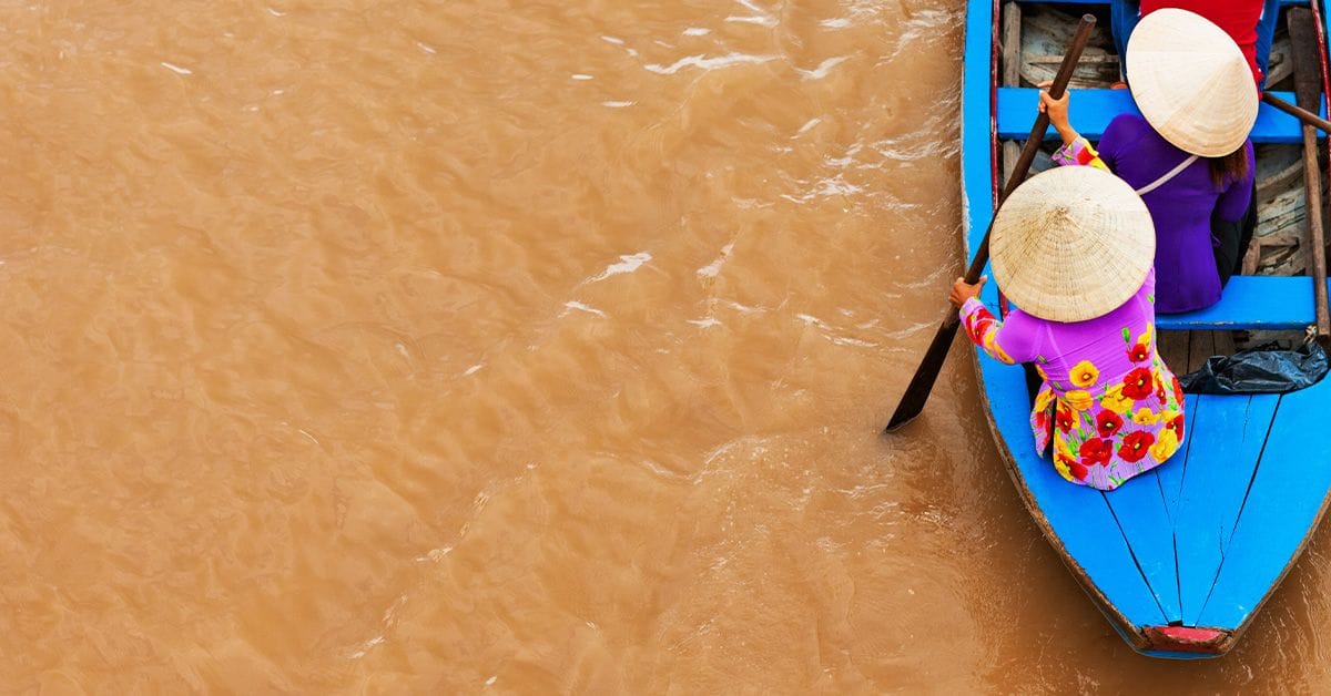 two people paddling a rowboat in Vietnam