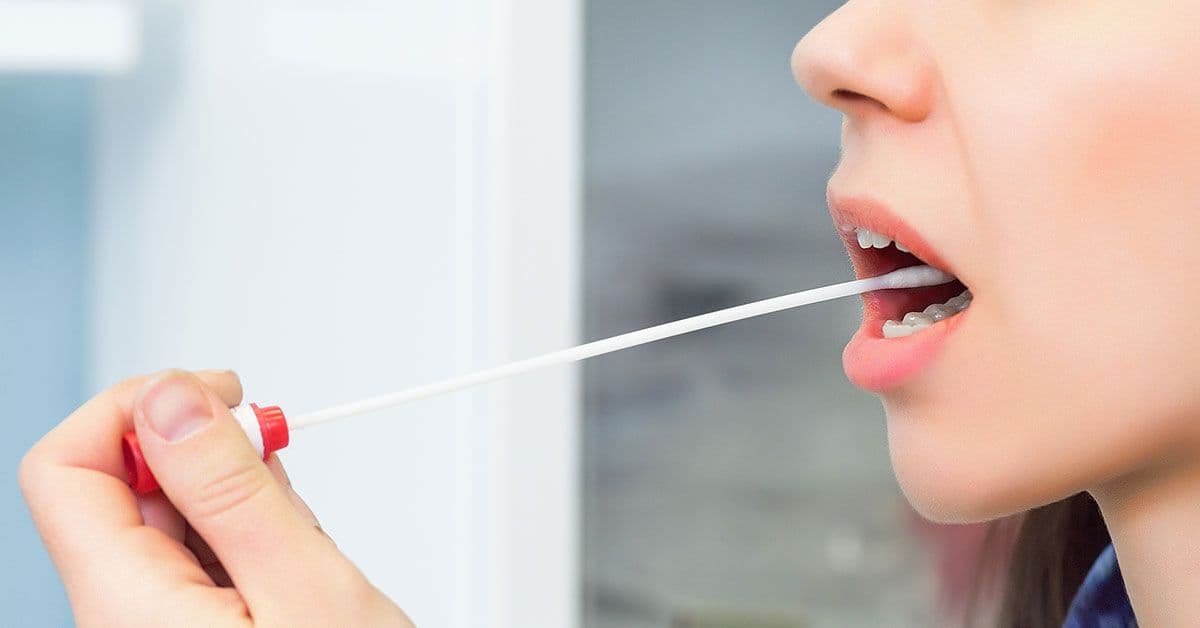 A woman is taking a syringe out of her mouth.