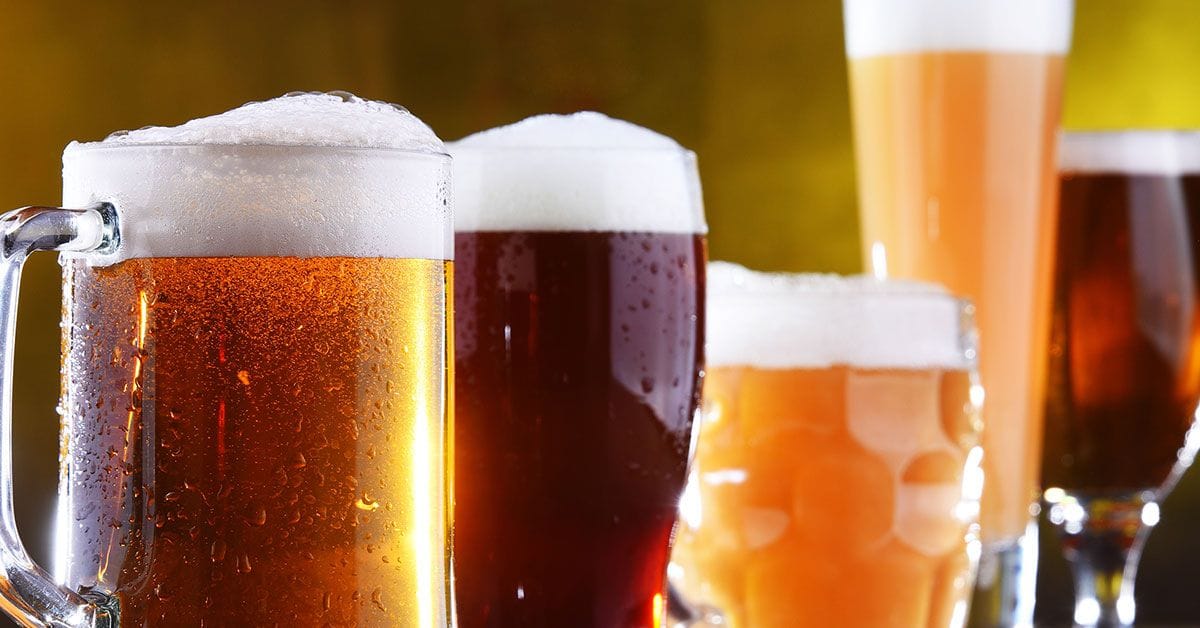 A group of beer glasses lined up on a table.