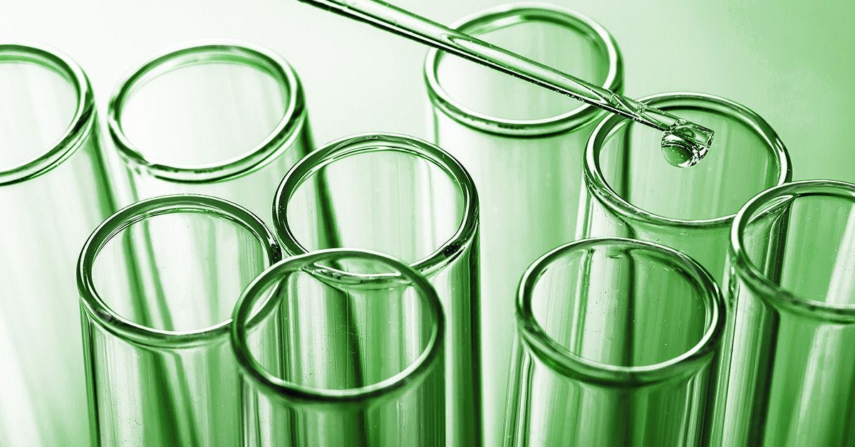 A pipette dispensing a liquid into a test tube among a set of test tubes on a green-tinted background.