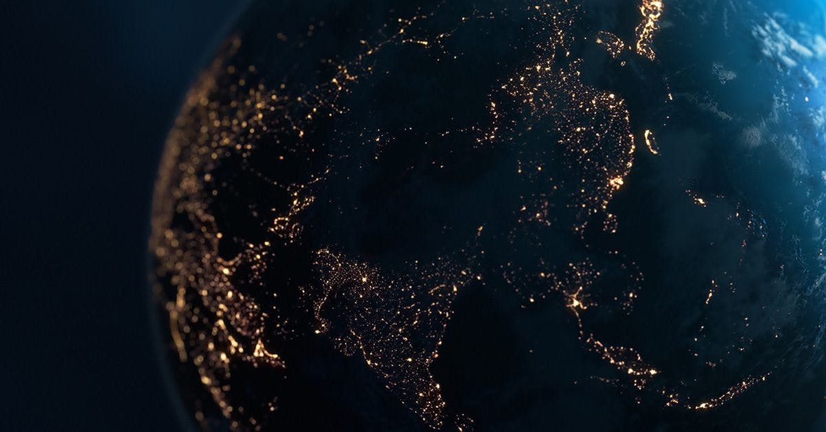 A high-resolution image of the earth at night showing illuminated city lights concentrated in europe and parts of asia, set against a dark backdrop.