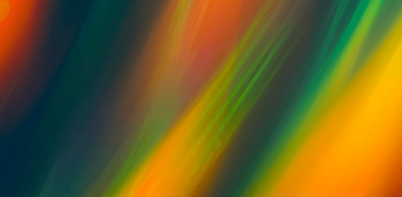 Abstract image featuring vibrant streaks of orange, green, red, and blue, blending together with a blurred, flowing effect.