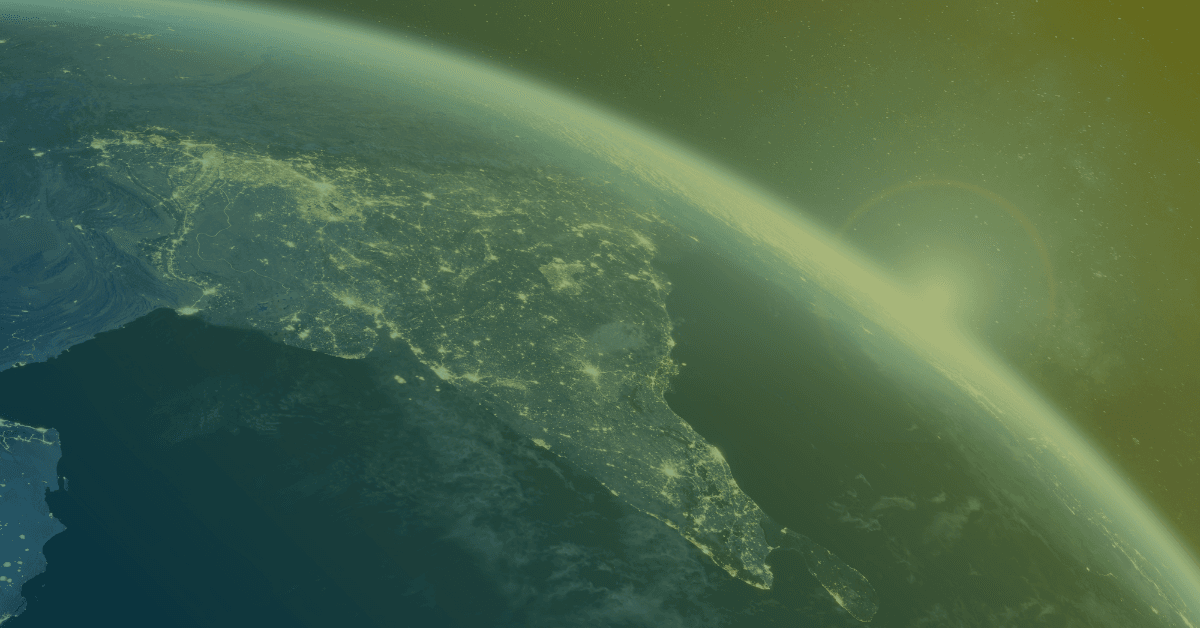 An aerial view of Earth highlighting the Indian subcontinent at night, illuminated by city lights against a starry background.