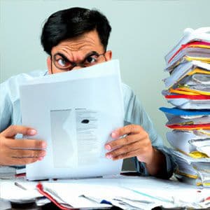 A man looking at a pile of papers.