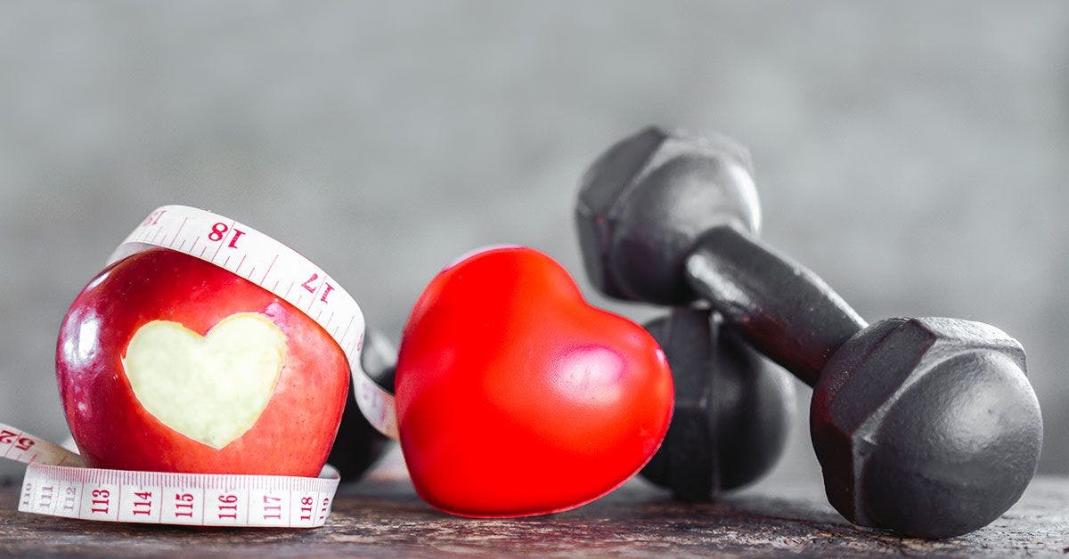 A heart shaped apple and a measuring tape.