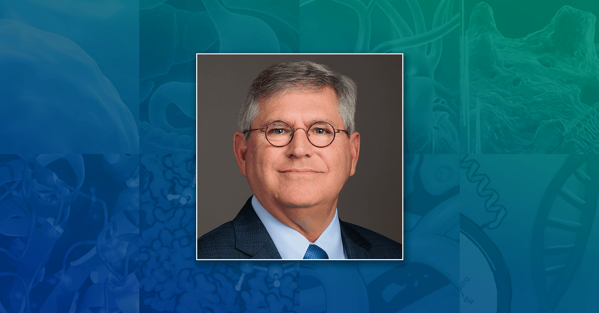 A headshot of Prof. John R. Yates, III, set against an abstract blue and teal background.