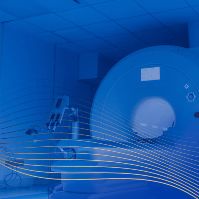 Blue‑toned illustration of an MRI scanner in a medical imaging suite with flowing wave lines.