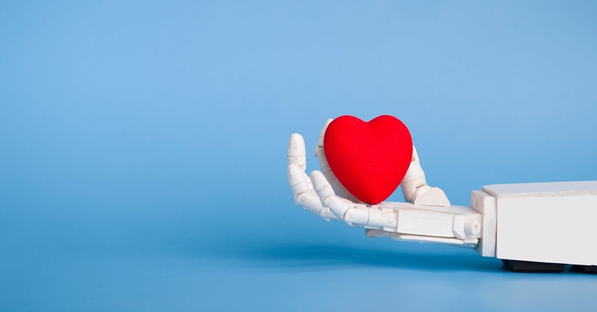 A robotic hand holding out a red, sponge-like heart against a blue background.