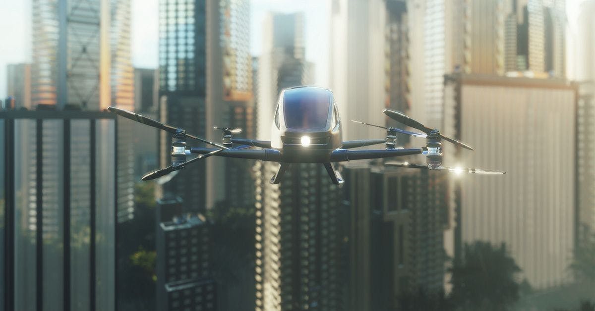 An eVTOL flying over a city with tall buildings.