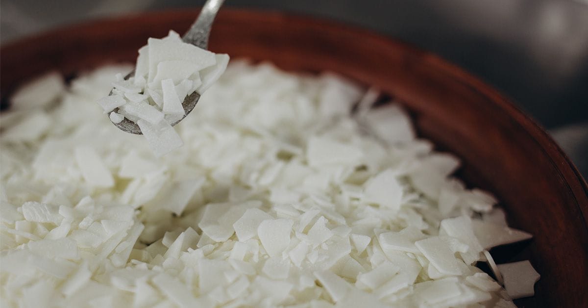 pieces of white soy wax flakes in a brown melting vessel