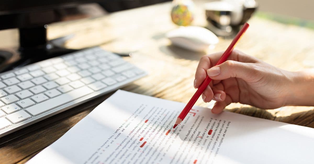 A person holding a pencil over a piece of paper.