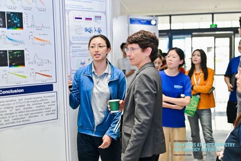 A presenter discussing their poster with Professor Carolyn Bertozzi.
