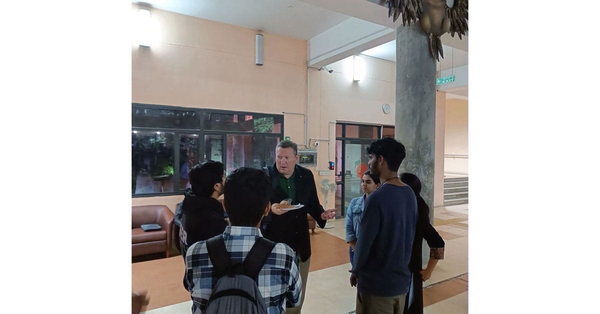 A group of people standing around in a room.