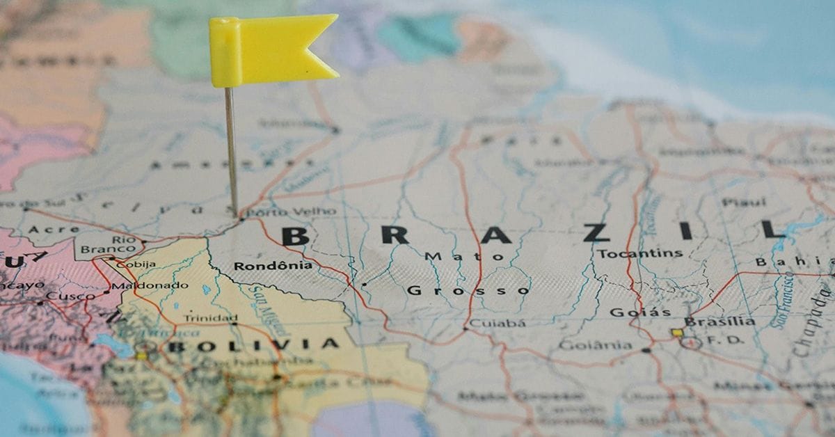 A close-up of a map highlighting Brazil, marked by a yellow flag pushpin, with neighboring Bolivia visible below.