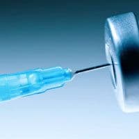 A blue syringe is being inserted into a needle.