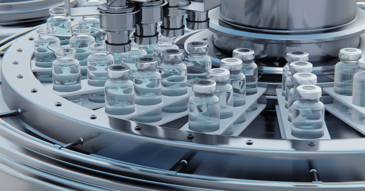 A close-up of a rotating machine filled with glass vials containing clear liquid, set on a sleek metallic platform.